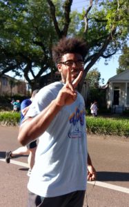 Young man runner holding up the peace sign.