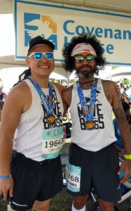 Two male runners smiling with sunglasses on.