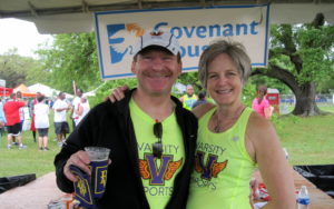 A man and woman enjoying a run and a drink in workout gear.