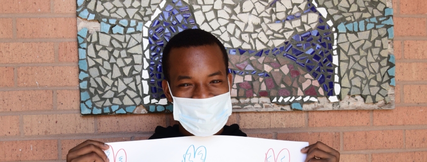 Teen wearing a mask while holding a "Thank you" sign