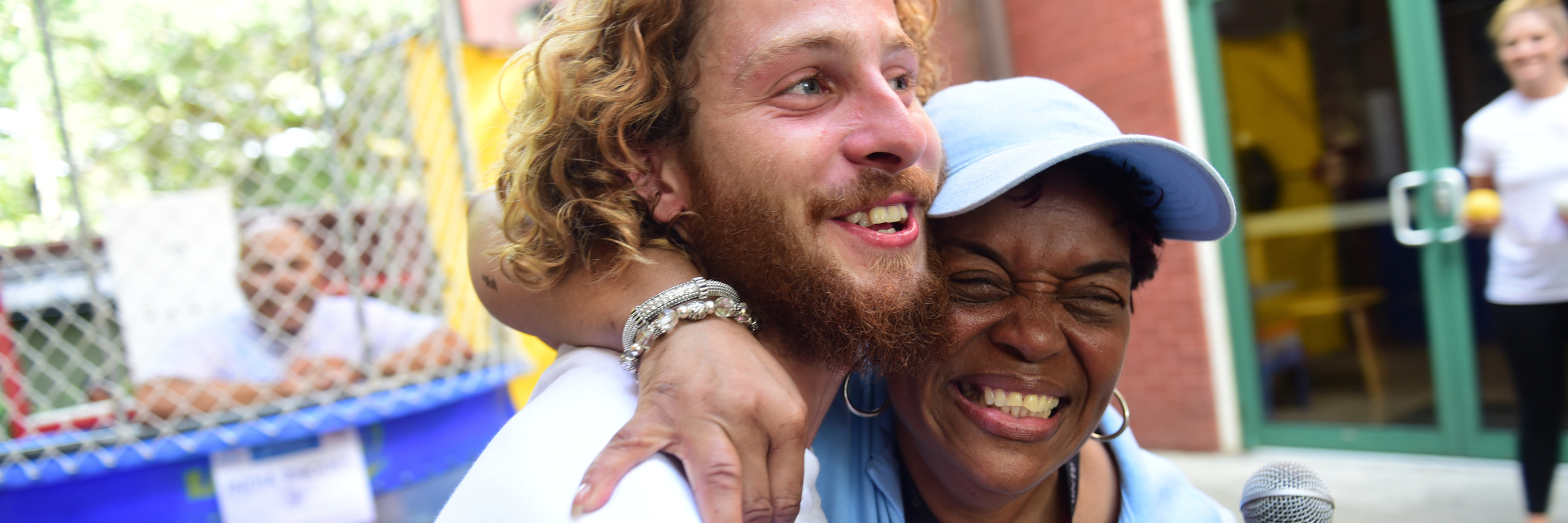 Mama Foots smiling with her arm around a man