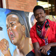 Close up of Elijah in front of some of his artwork