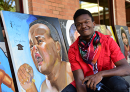 Close up of Elijah in front of some of his artwork