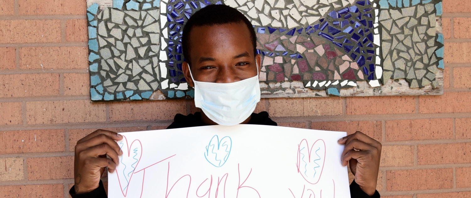 Covenant house resident holding a thank you sign