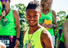 Jakiya smiling while posing with his silver medal after one of his races