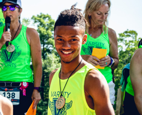 Jakiya smiling while posing with his silver medal after one of his races