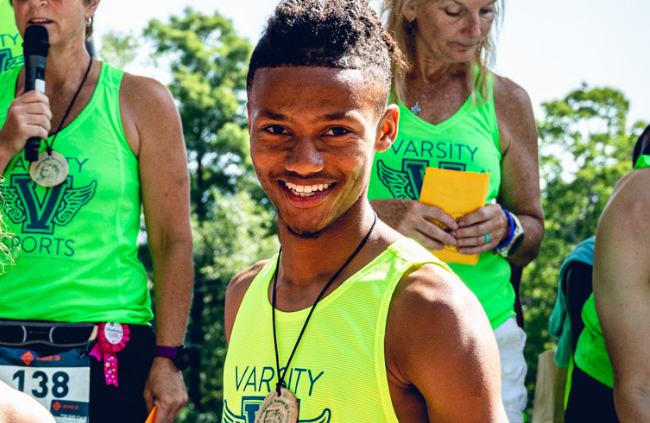 Jakiya smiling while posing with his silver medal after one of his races