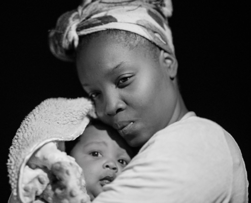 A mother hugs a baby close to her chest.