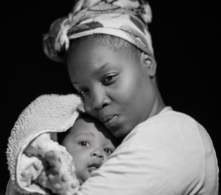 A mother hugs a baby close to her chest.